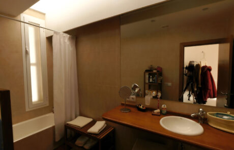 Baño completo de una vivienda con artículos de higiene en el lavando