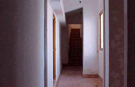 pasillo de una iglesia convertida en vivienda, al fondo se ven las escaleras