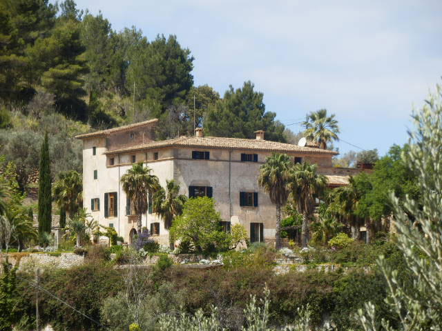 Vista de la fachada exterior de una vivienda rodeada de vegetación