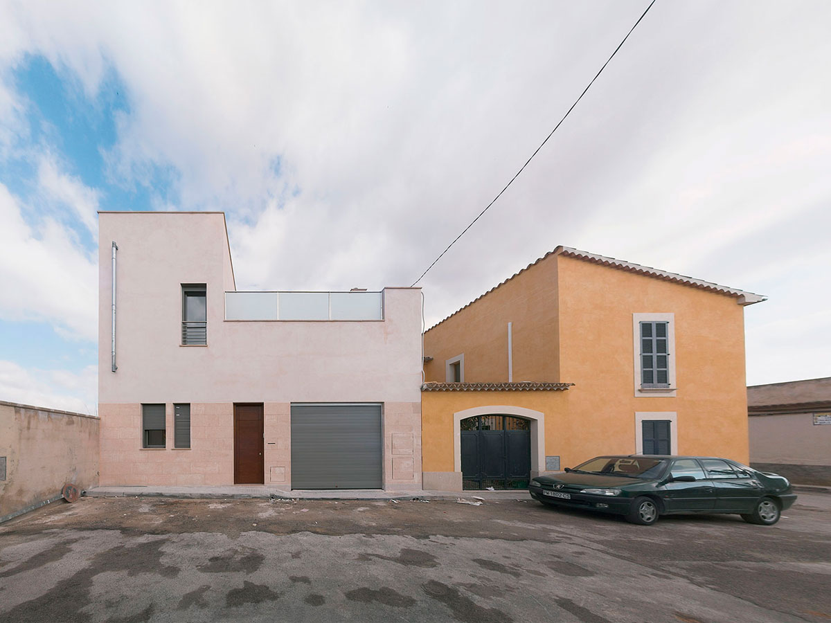 Fachada exterior de una vivienda, se ve un coche aparcado
