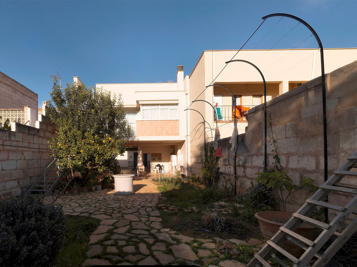 patio trasero de una casa adosada, el patio está parcialmente pavimentado con losas de piedra.