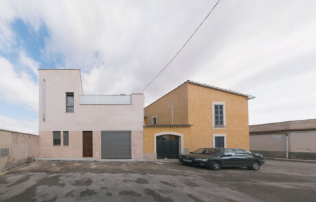 Fachada exterior de una vivienda, se ve un coche aparcado